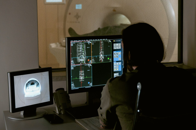 Mehrere Röntgenaufnahmen. Im Hintergrund steht ein MRT.