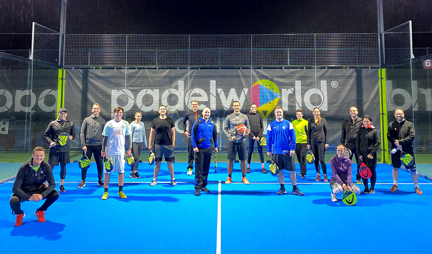 Gruppenbild der think about IT Mitarbeiter auf einem Tennisplatz nach einem Paddle-Tennis-Turnier.