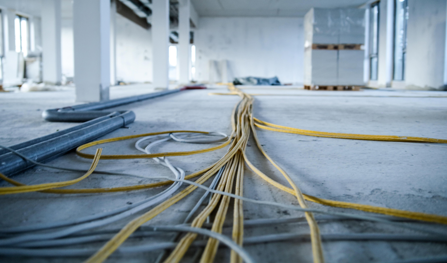Kabel verlaufen über den Boden im Neubau des think about IT Headquarters.