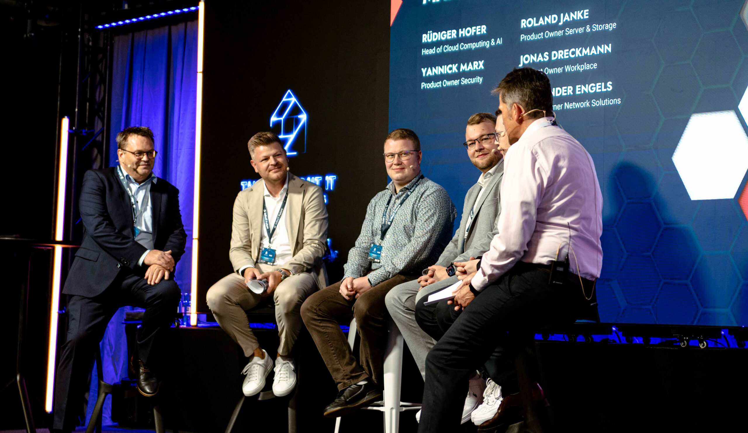 6 Personen, die auf einer Bühne eine Podiumsdiskussion führen auf der Hausmesse der think about IT.