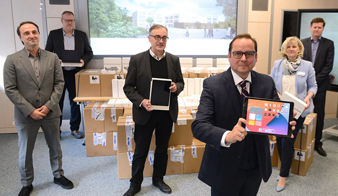 Eine große Lieferung von Tablets wird von Lehrern präsentiert, die ihre neue digitalisierte Ausstattung zeigen.