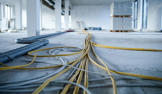 Kabel verlaufen über den Boden im Neubau des think about IT Headquarters.