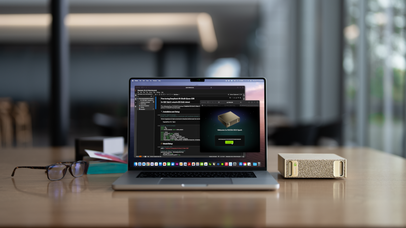 Ein Schreibtisch mit einem Laptop. Rechts neben dem Laptop liegt der NVIDIA DGX SPARK in seiner kompakten Größe, etwas kleiner als ein herkömmliches Buch.