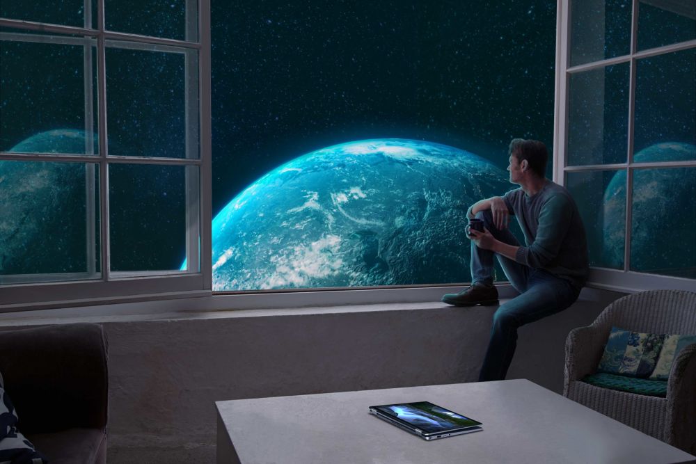 Ein Mann, der aus dem Fenster auf einen Planeten schaut.