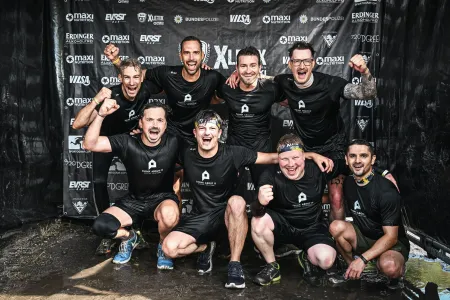 Eine Gruppe jubelnder Person der think about IT, nach Abschluss der Xletix Challenge.