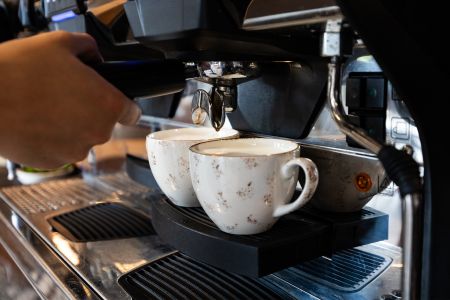 Zwei gefüllte Kaffeetassen an einer Kaffeemaschine.
